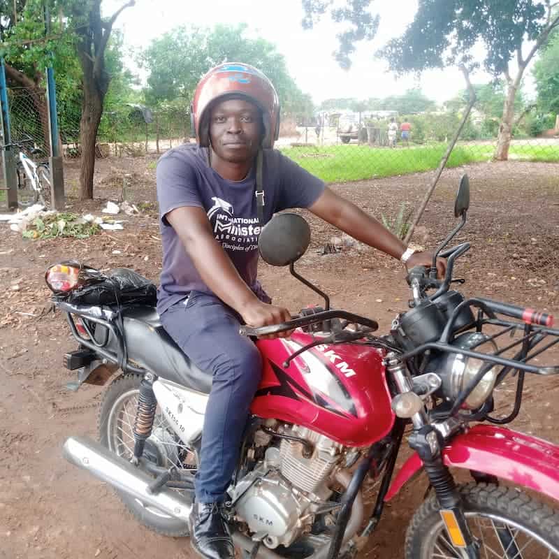 Allen Mwenye with his bike donated by the bfp program